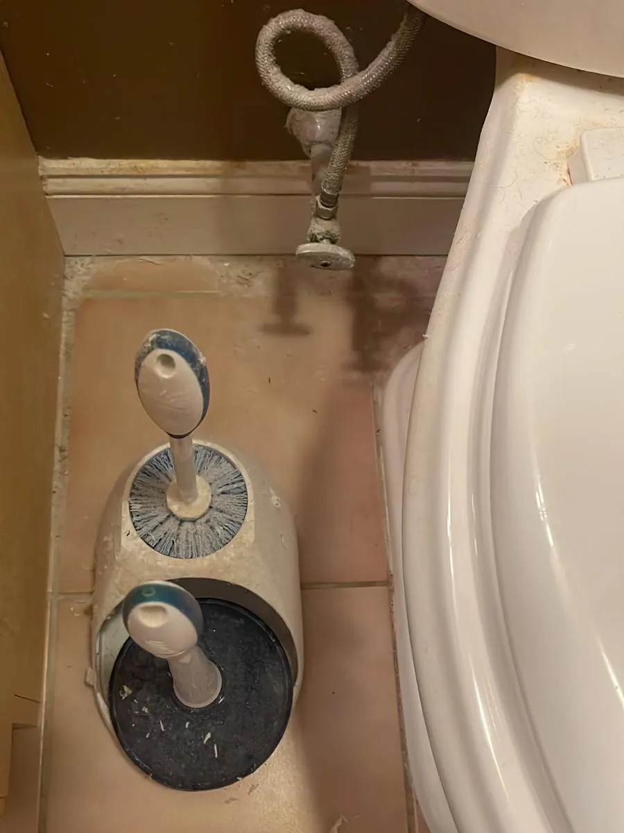 Bathroom floor tile and fixtures before deep cleaning in Clinton, MA, with dust and grime