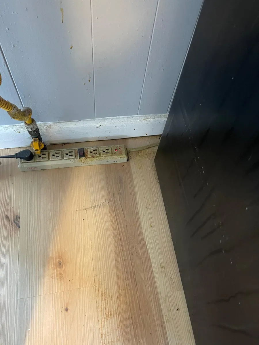 Hardwood floor and baseboard after a post-construction deep cleaning in Clinton, MA — clean boards and trim